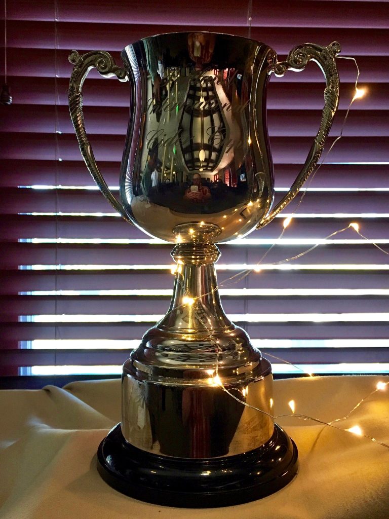 A silver trophy sitting on top of a table.