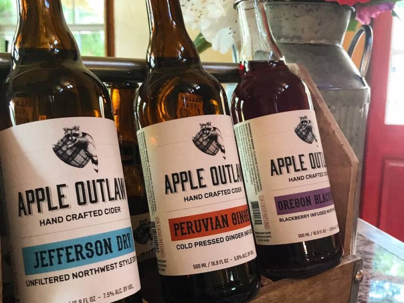Three bottles of apple quill and jefferson bourbon on a table.